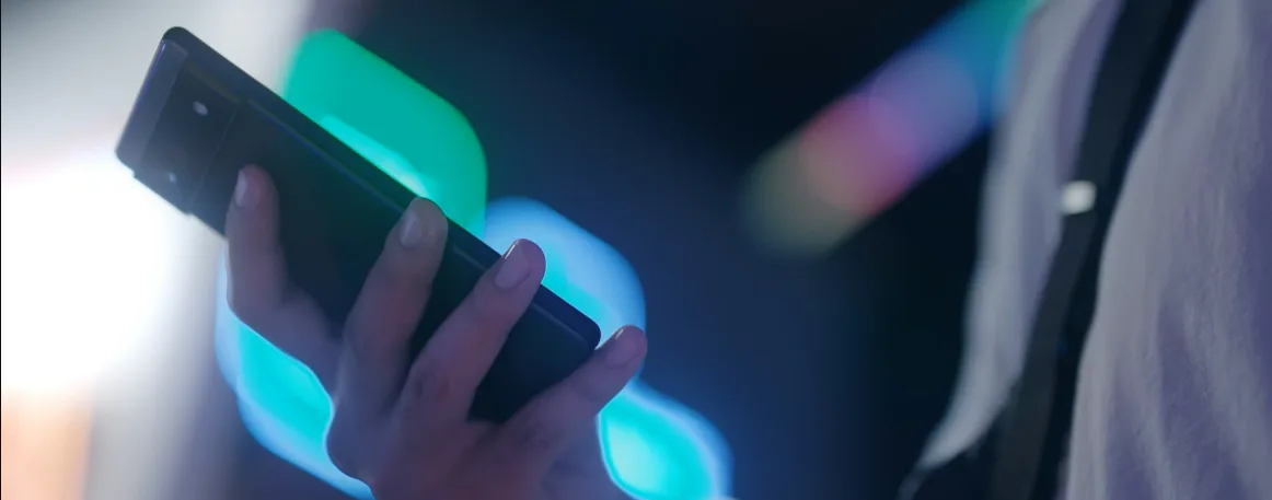 Hand holding a smartphone with a digital ticket at a festival entrance