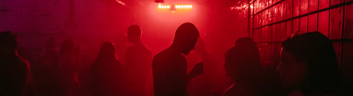 Underground warehouse rave with silhouettes of ravers and lights